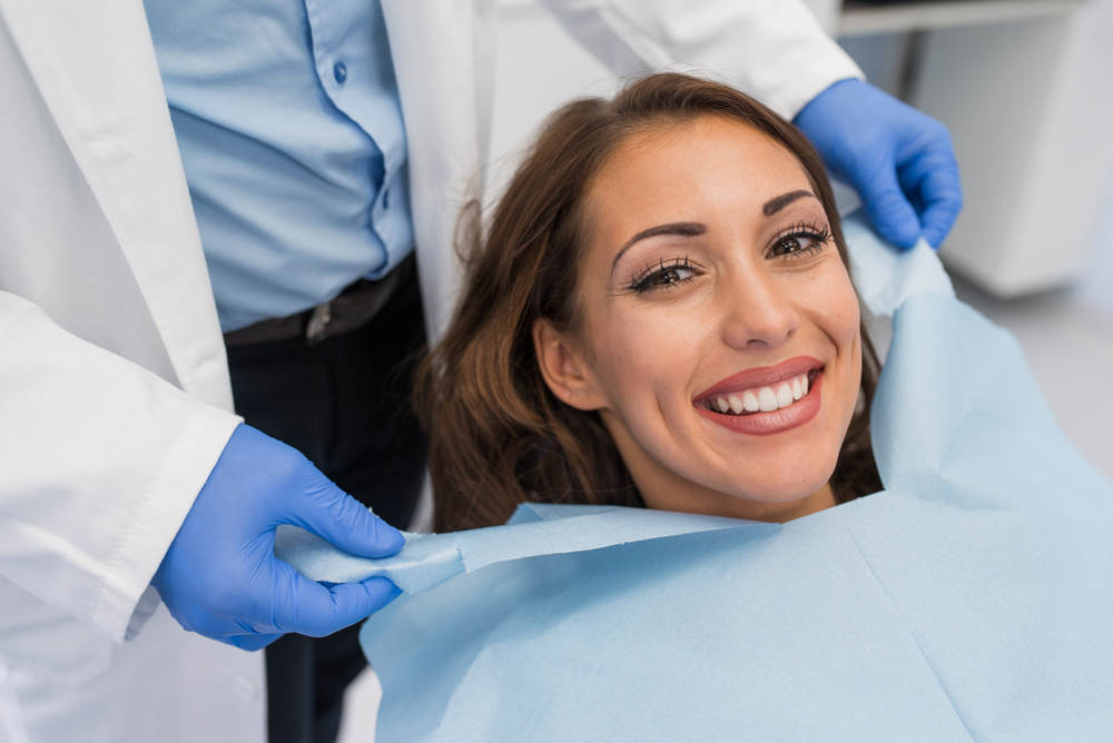 Doctor,Fixing,Female,Patient,Napkin,In,Modern,Dental,Clinic