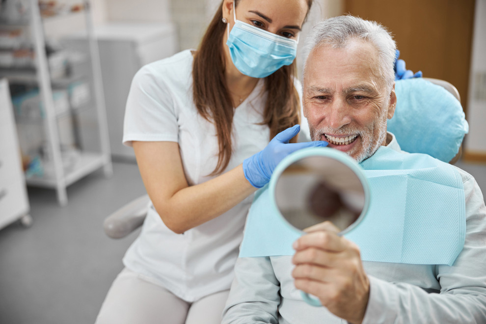 Elderly,Man,And,His,Young,Female,Dentist,Smiling,While,Looking