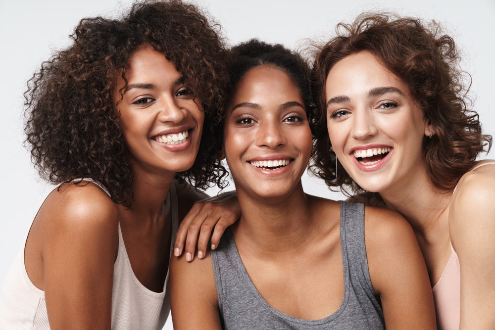 Portrait,Of,Three,Young,Multiracial,Women,Standing,Together,And,Smiling
