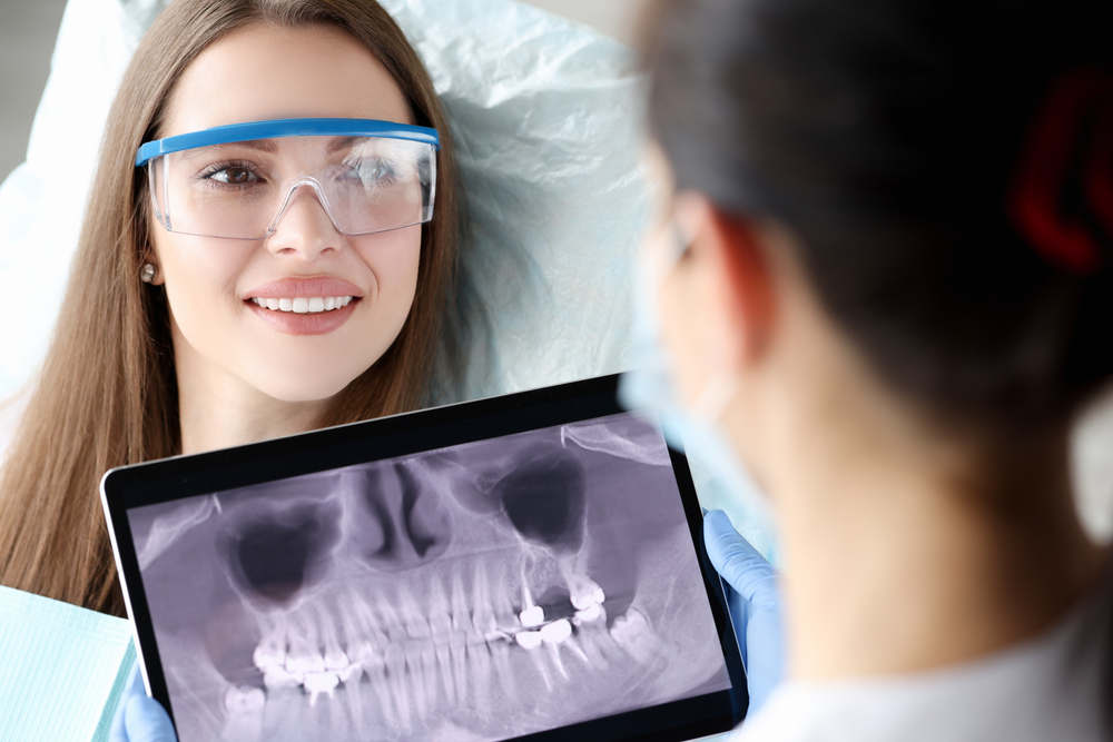 Dentist,Holding,Digital,Tablet,With,3d,Picture,Of,Teeth,In